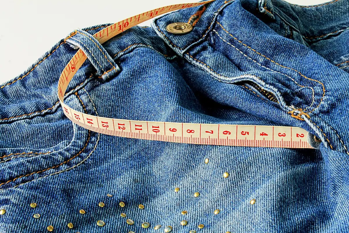 Personne mesurant l'espace d'assise avec un mètre ruban